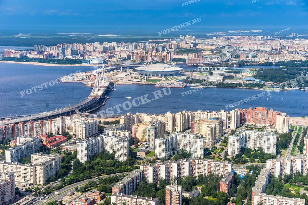 Аэрофотосъемка демонстрирует великолепный вид на Западный скоростной диаметр и окружающие жилые районы Санкт-Петербурга. Эта фотография иллюстрирует развитие городской инфраструктуры и может быть использована в градостроительных проектах, а также для публикаций о современной архитектуре и городском планировании.